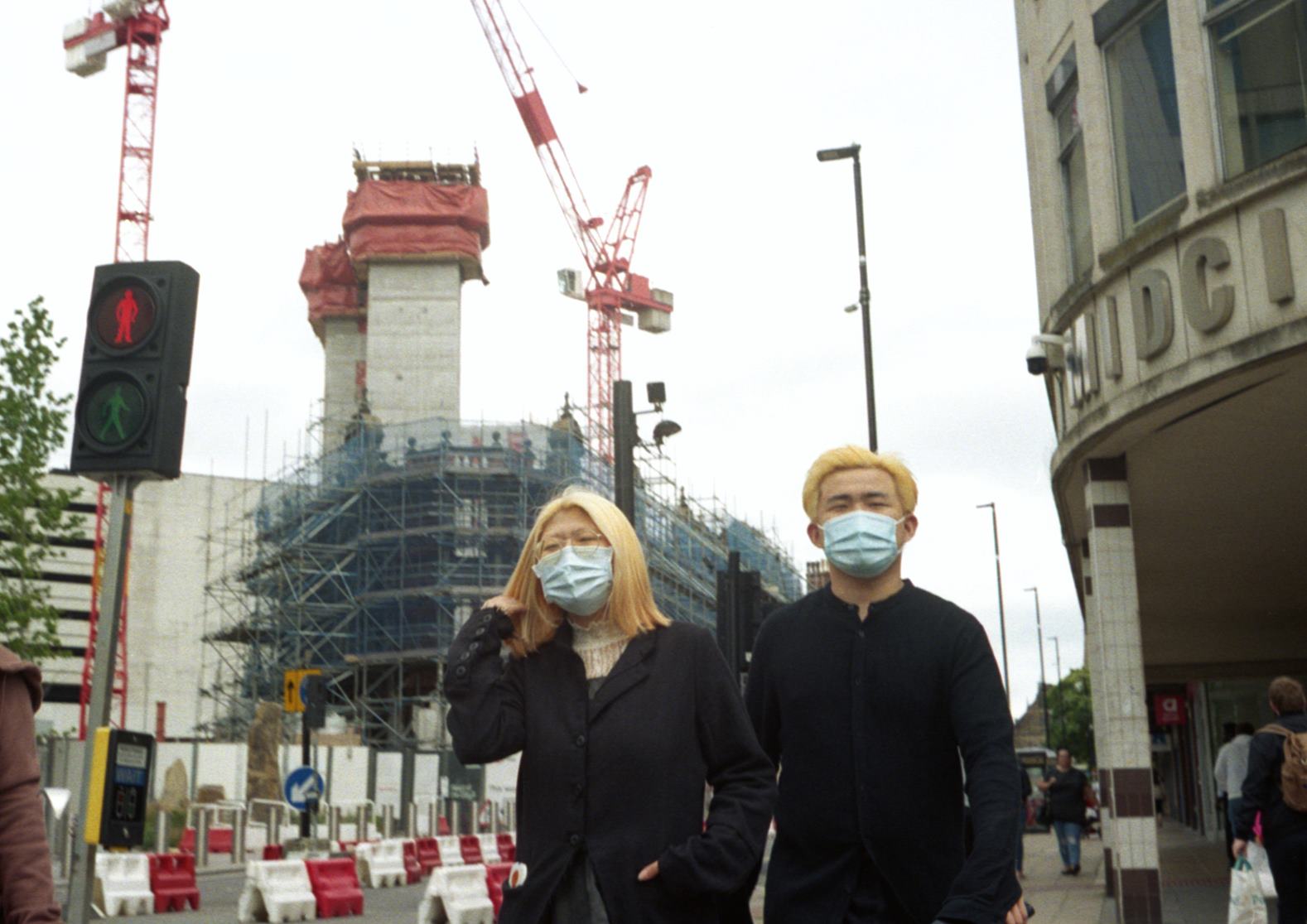 two people with matching dyed blonde hair and surgical masks