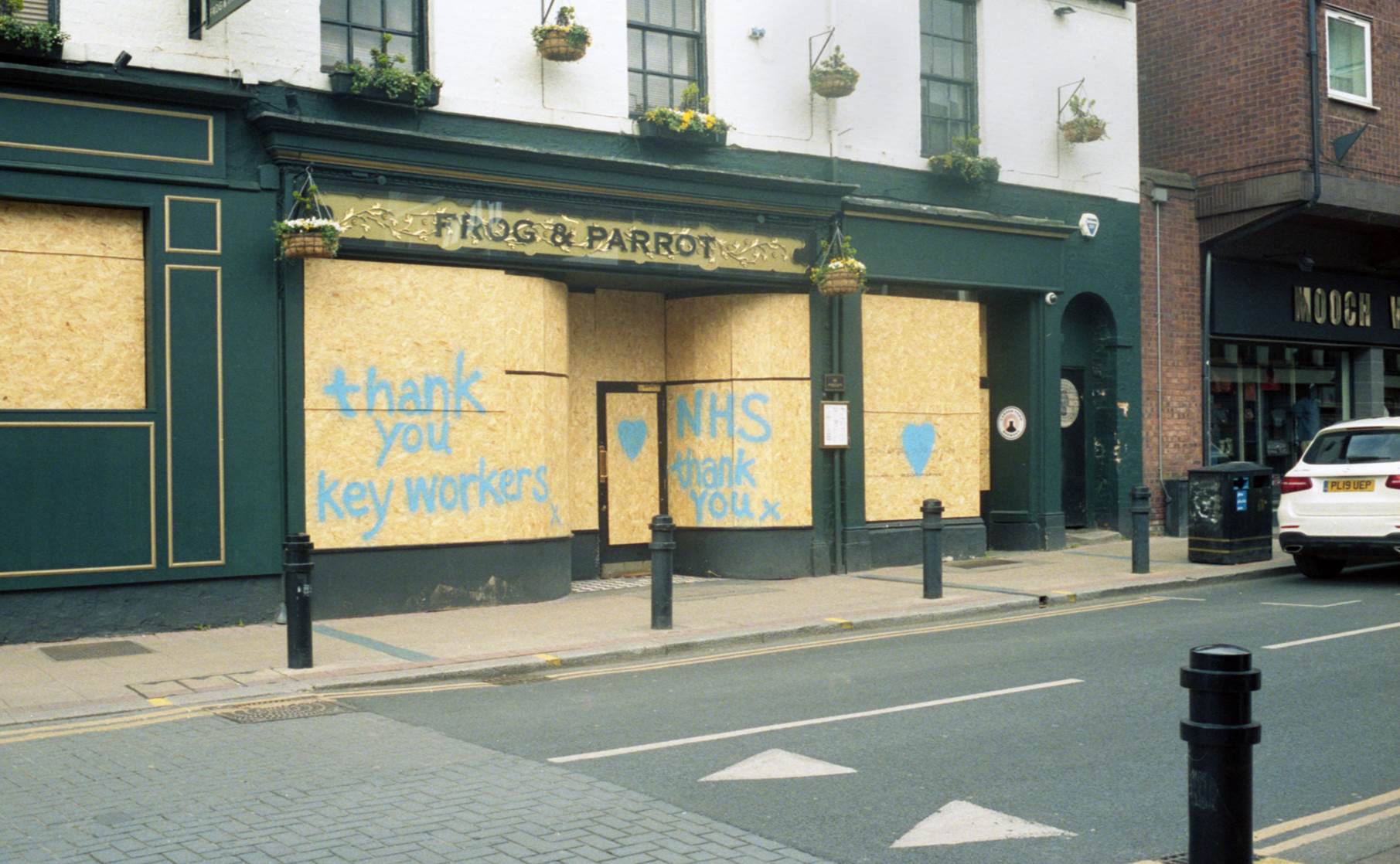 boarded up Frog & Parrot pub with spray painted messages of support for NHS and keyworkers